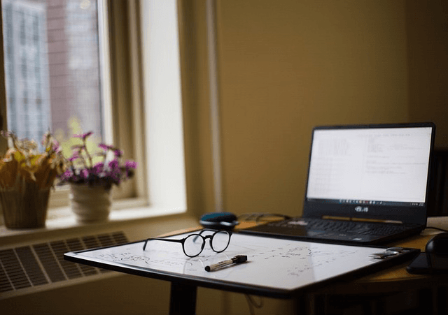 Glasses and a laptop placed on a study desk